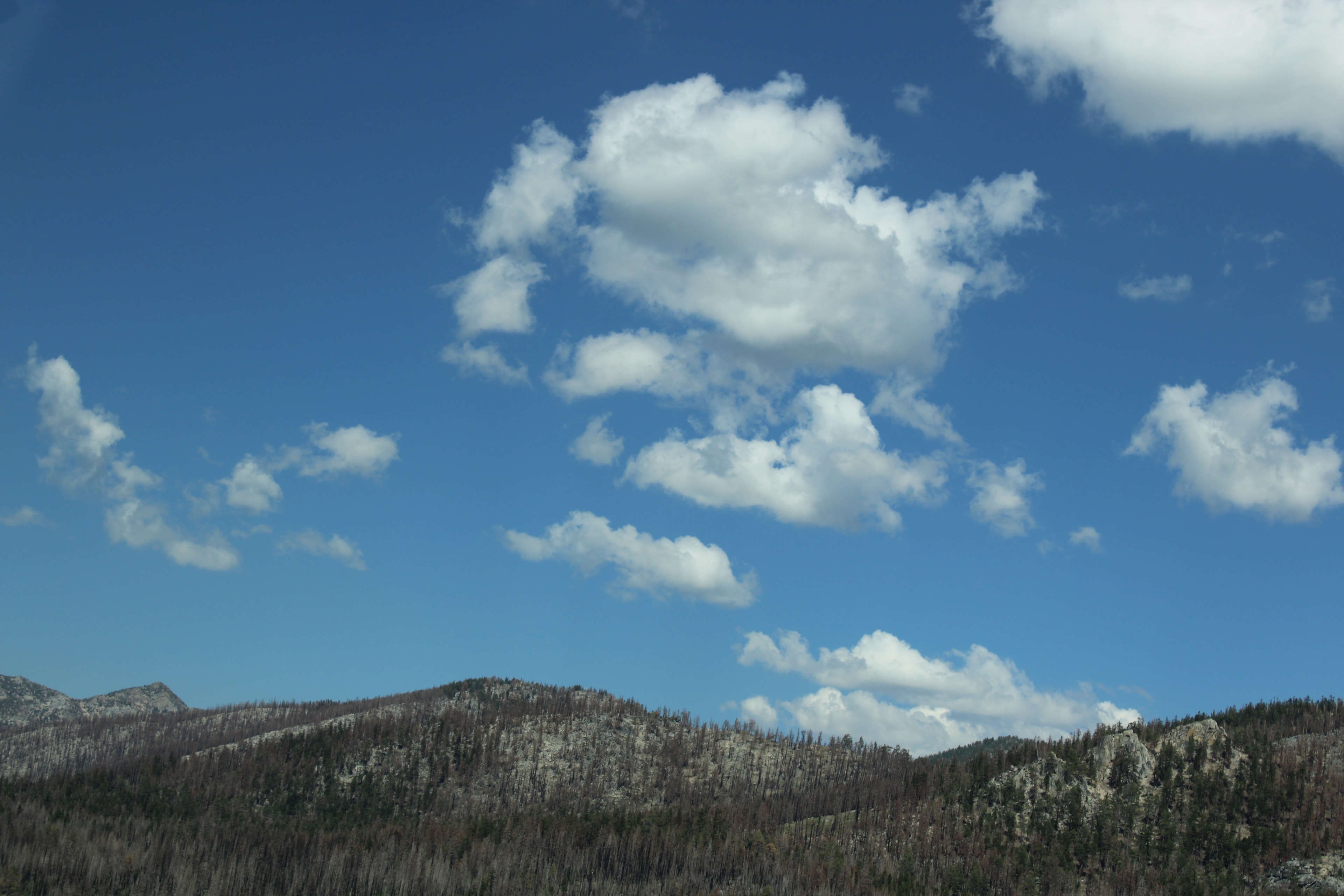 Mountains under bright blue sky with white clouds